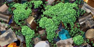 Recycling green plant globe map surrounded of rubbish